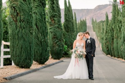 Bride and Groom share a tender moment in the road at the Bella Vista Groves wedding venue in Fillmore, CA