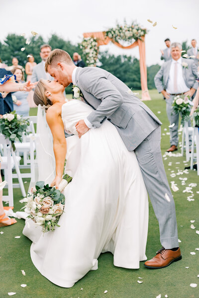 Groom dips his bride for a kiss after taking wedding vows