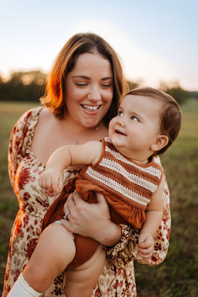 mom holding baby in striped outfit