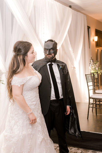 groom in Batman mask and cape at wedding with bride