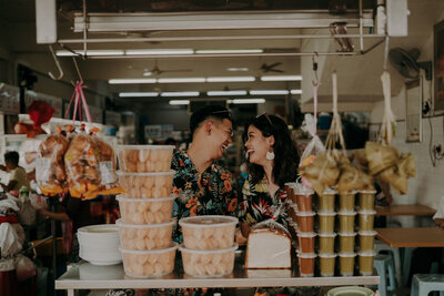 couple laughing at each other with malaysia traditional snack