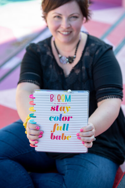 Woman's hands holding a planner with the words "Bloom stay color full babe" on the cover - Bloom by bel monili