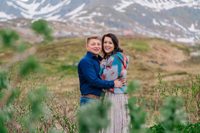 An engaged couple snuggling in the mountains at sunset during the fall enjoying their Raleigh wedding photos
