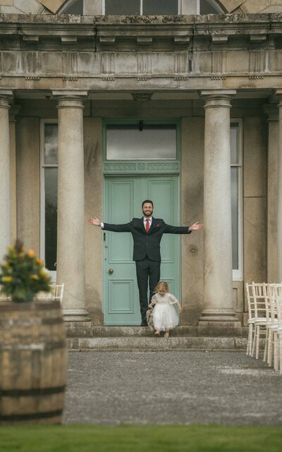Man with child, arms open wide, enjoying a joyful moment at Netherdale House, Aberdeenshire, capturing the warmth and connection between father and child