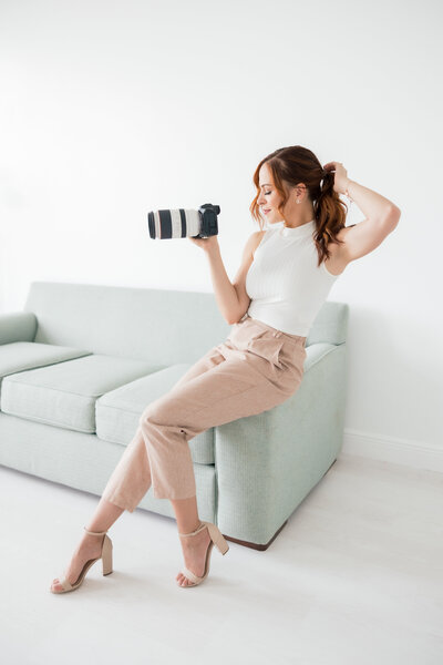 Florida and Palm Beach Wedding photographer Angelika Krug holding a camera for the contact page.