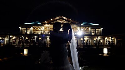 A wedding couple about to kiss at night.