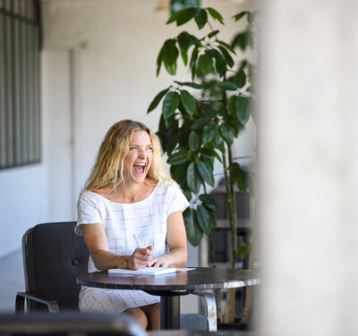 woman  sitting looking out the window and big open mouth smile