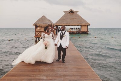 Bride and groom walking on dock after wedding in Cancun