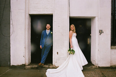A bride and groom standing in doorways next to each other.