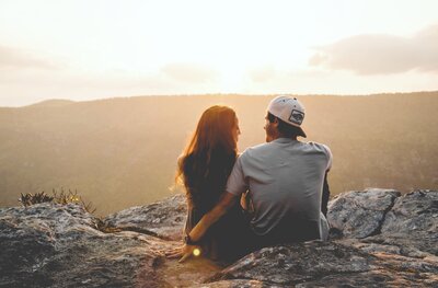 Couple sitting together on a cliffside
