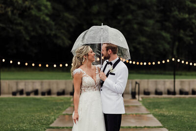 Couple looking at each other while standing under umbrella
