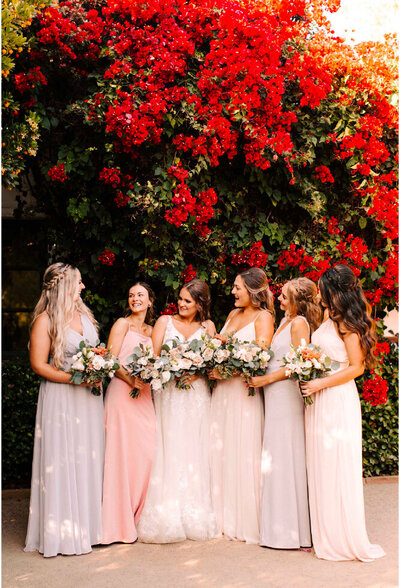 bridal party under tree with red flowers