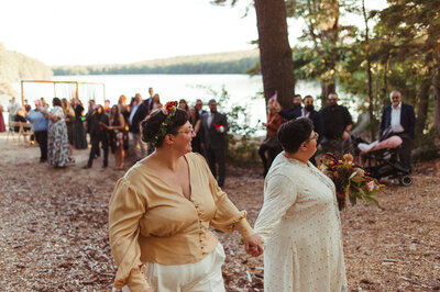Couple holding hands leaving wedding ceremony - UME (New England Wedding Planners were wedding vendors)