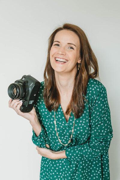 photographer holding a camera and smiling