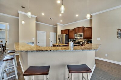 Kitchen island with bar height seating in this three-bedroom, two-bathroom vacation rental lake house that sleeps eight just steps away from Stillhouse Hollow Lake in Belton, TX.