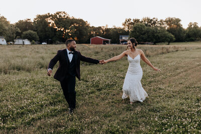 destination elopement photographer captures bride and groom running through field together