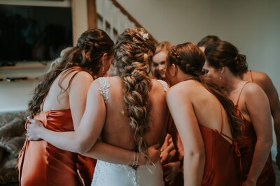 Bride and bridesmaids in rust color dresses,