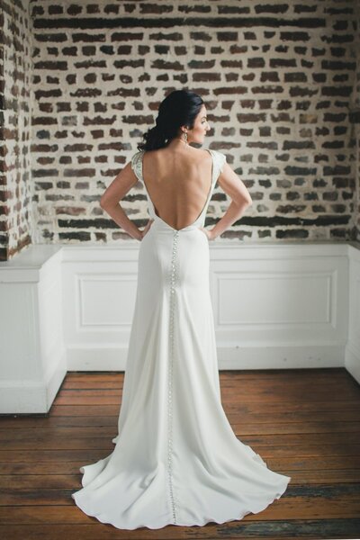 Link to more details and photos of the Tamarisk crepe wedding gown style with its high neck and low open back.
