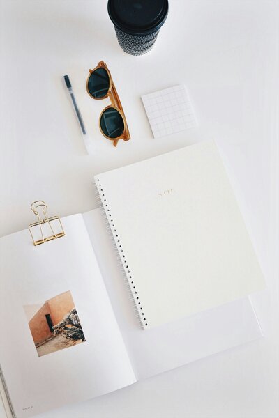 notebook, glasses and papers on desktop