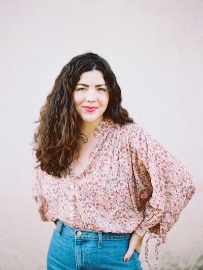 Amber wearing floral top and jeans as a Austin wedding photographer