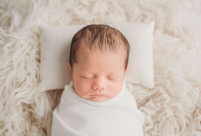 Sleeping newborn wrapped up during his san diego newborn photo session
