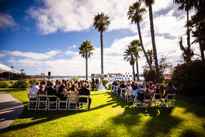 Wedding ceremony set up at La Valencia San Diego with white rose petals and circular floral arch