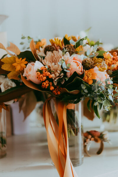 a selection of flowers sits in vases with pink and orange color tones