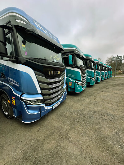 Řada moderních nákladních vozů IVECO ve firemních barvách Audo Viktoria připravená k přepravě
