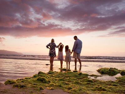 A family of four watches sunset on the north shore  oahu