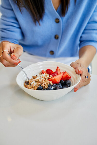 nutritionist near me eating healthy breakfast of granola and berries for gut health