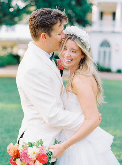 Golden light shines through outdoor garden wedding ceremony in Charleston. Bridesmaids in black.