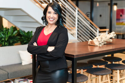 Business Coach poses with arms crossed in a leather black skirt