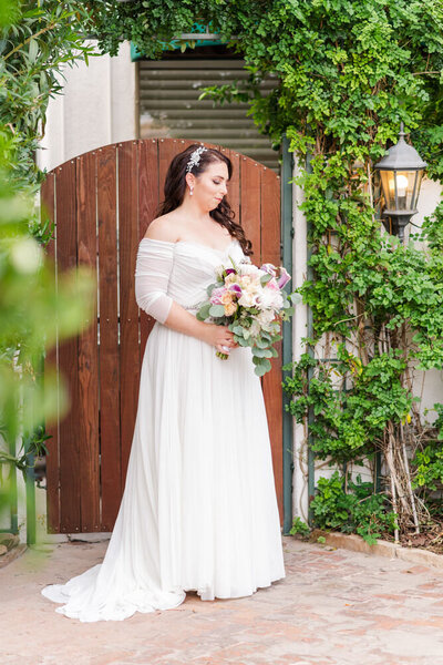 portrait of bride in courtyard surrounded by ivy
