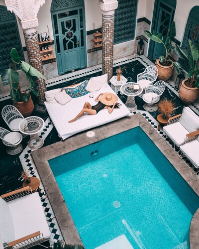 Woman sun bathing pool side in luxury hotel in Morocco