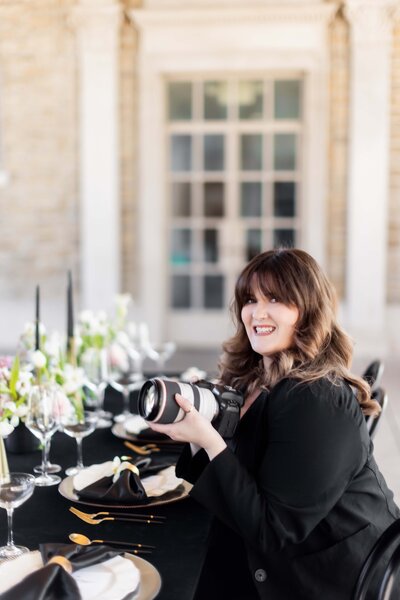 Abby Gehron, a talented Lead Photographer and Editor, is captured here during a vibrant wedding shoot. This photo illustrates her creative process and eye for capturing joyful, dynamic moments that resonate with bridal couples.