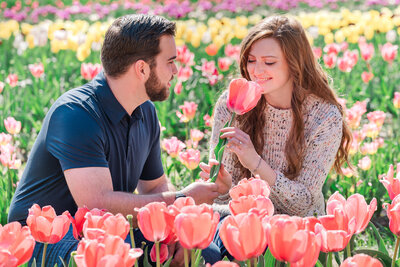 An engaged couple in a field of vibrant tulips in Raleigh during the spring enjoying their Raleigh wedding photography session with JoLynn Photography