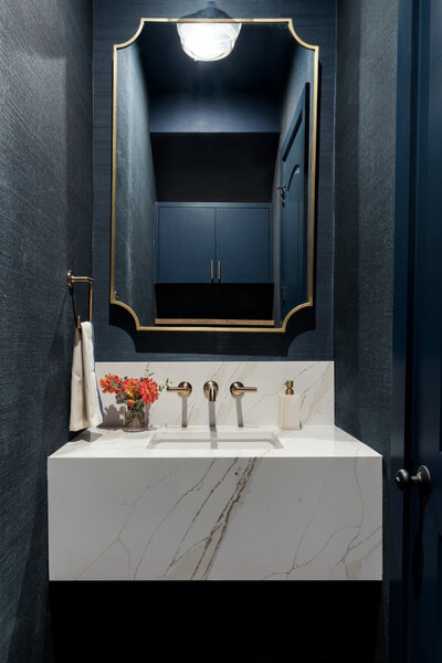 blue bathroom. white quartz sink. gold geometric mirror  bathroom styling. how to style your bathroom with baskets. austin tx