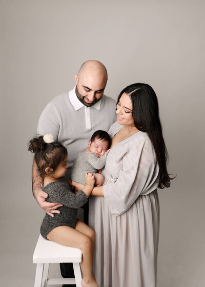 Family posed in studio newborn session in Orange County CA by Ashley Nicole.