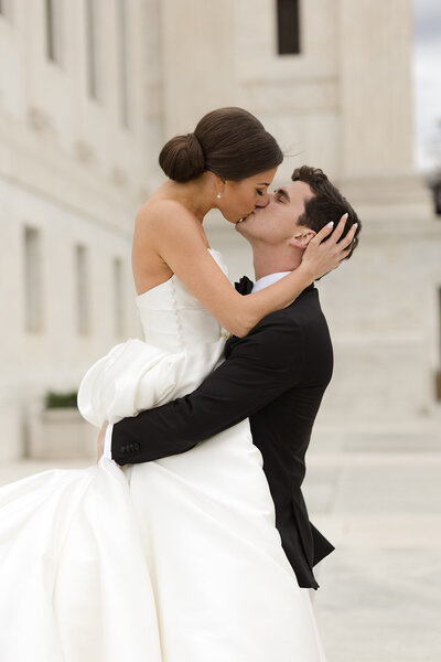 Bride and groom kiss at an elegant, classic wedding