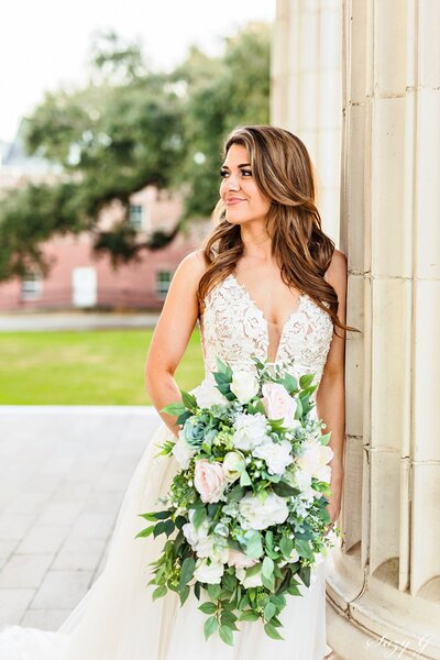 Stunning bride in wedding gown with cascading bouquet, hair is down and flowy.