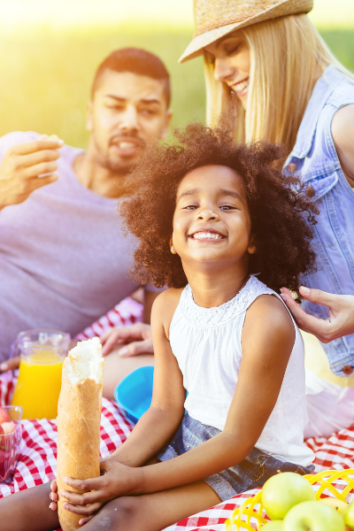 Thrive by Spectrum Pediatrics image for family mealtime coaching service is a happy family eating a picnic during family mealtime
