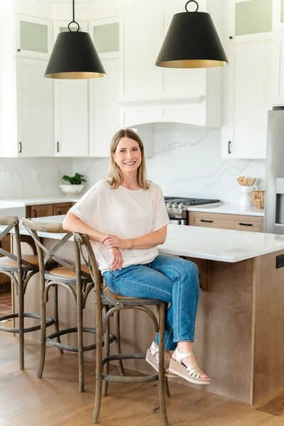 Emily Ziegler, co-owner of Heather Paperie, sitting at kitchen island, ready to design custom wedding invitations