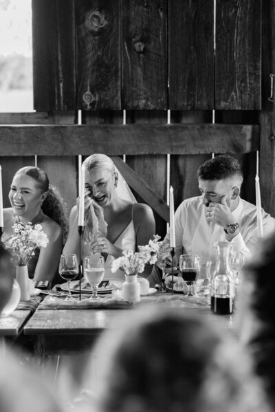 bride and groom tear up while listening to guest toasts