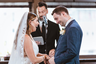 Bride and groom laugh during their wedding ceremony