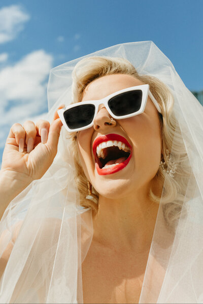 Bride with red lipstick and white sunglasses