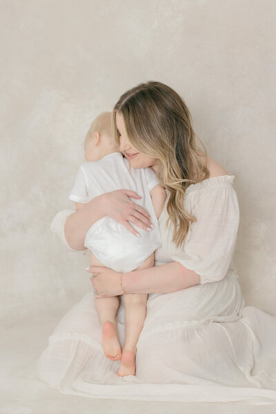 Mom and her young son hugging in all white studio by NJ photographer