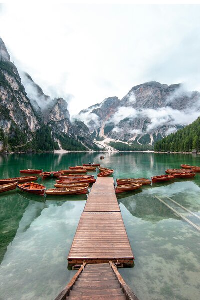 Image of  Lago di Brais, with a jetty on the crystal clear waters and lots of pretty boats