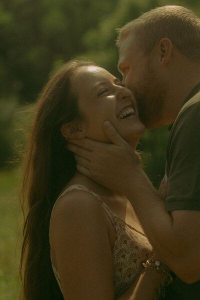Man and woman romantically spin around, laughing in the middle of a  flowery field
