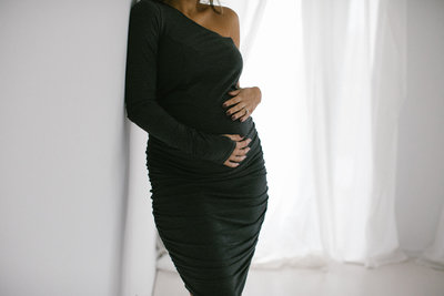 pregnant woman holding her belly with her hands during a photography session with Laurie Baker
