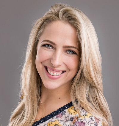 Young blonde woman headshot wearing floral top